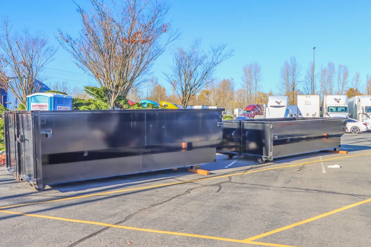 Professional dumpster rental service with roll-off container on residential driveway in Storm Lake